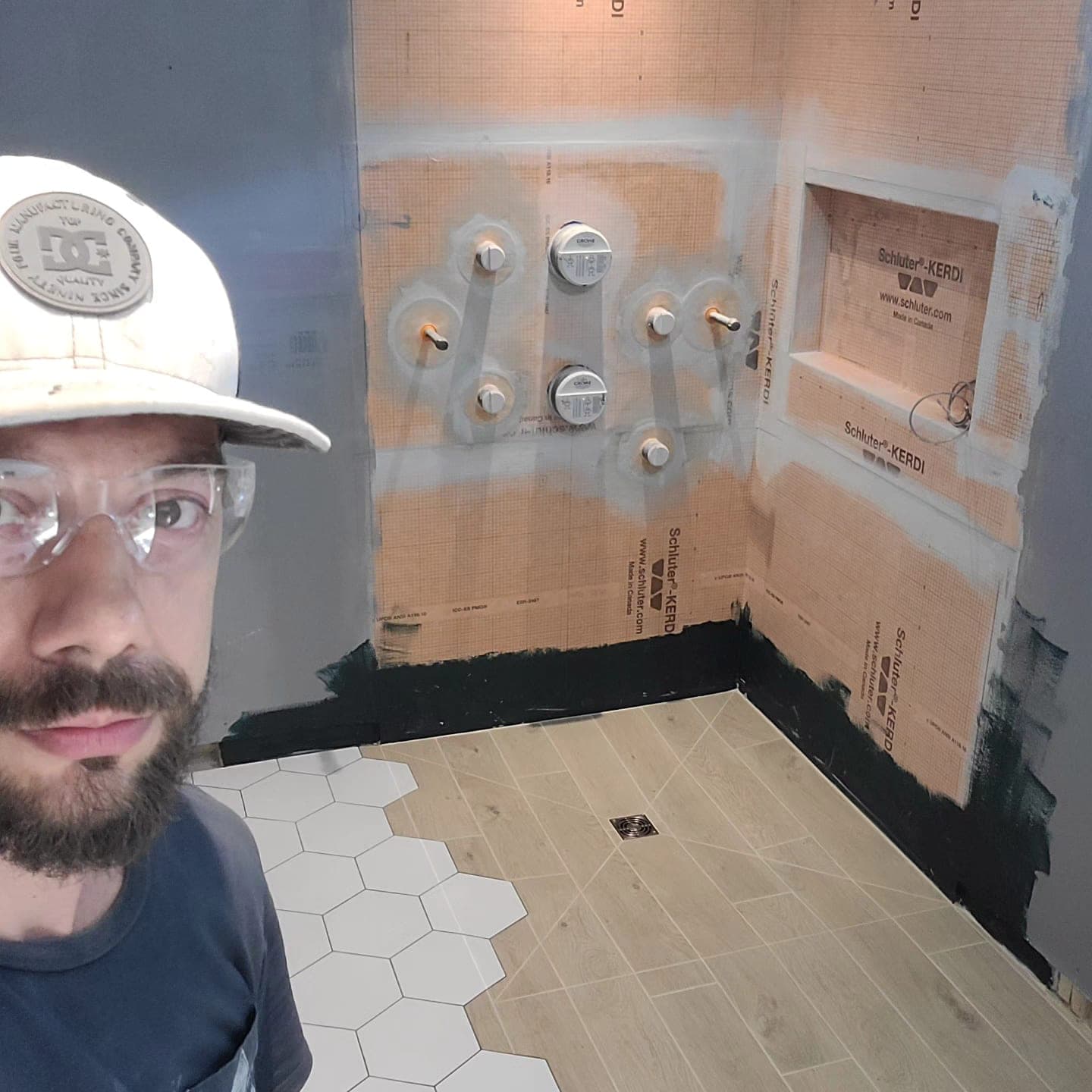 Phil mid-install on a Toronto job site, Schluter Kerdi-waterproofed shower behind him