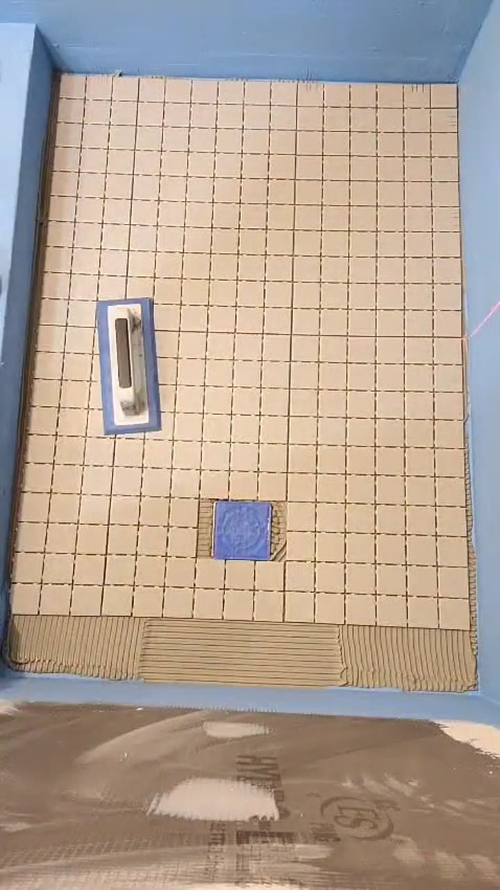 Phil installing small-format mosaic on a shower pan over Mapei AquaDefense waterproofing