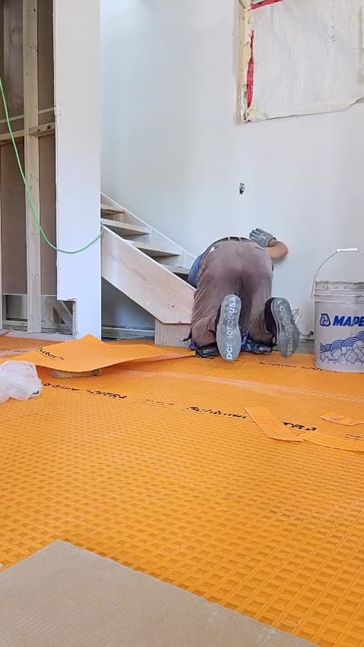 Phil installing Schluter Ditra uncoupling membrane on a floor before tile
